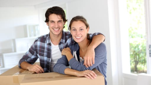 couple leaning on boxes in new home
