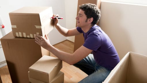 man labelling packing boxes