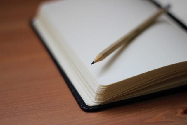A pen resting on an opened notebook